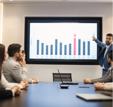 A Person Showing Presentation On Large Screen To Group Of People 